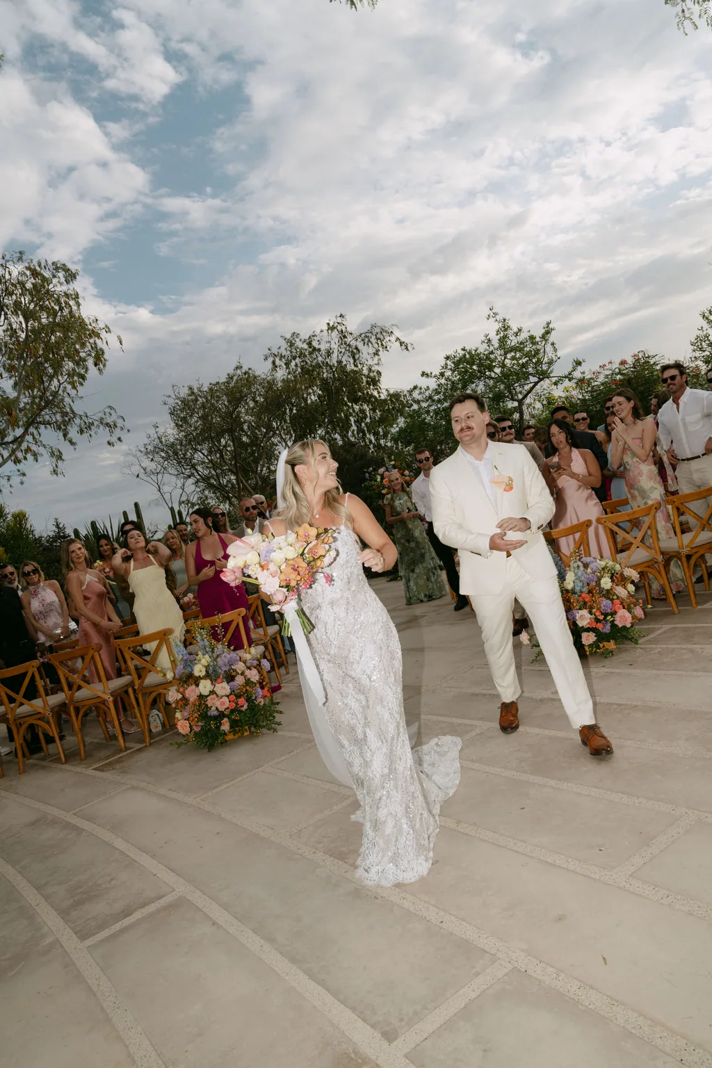 Bailey laughing as she walks back down the aisle with her bouquet
