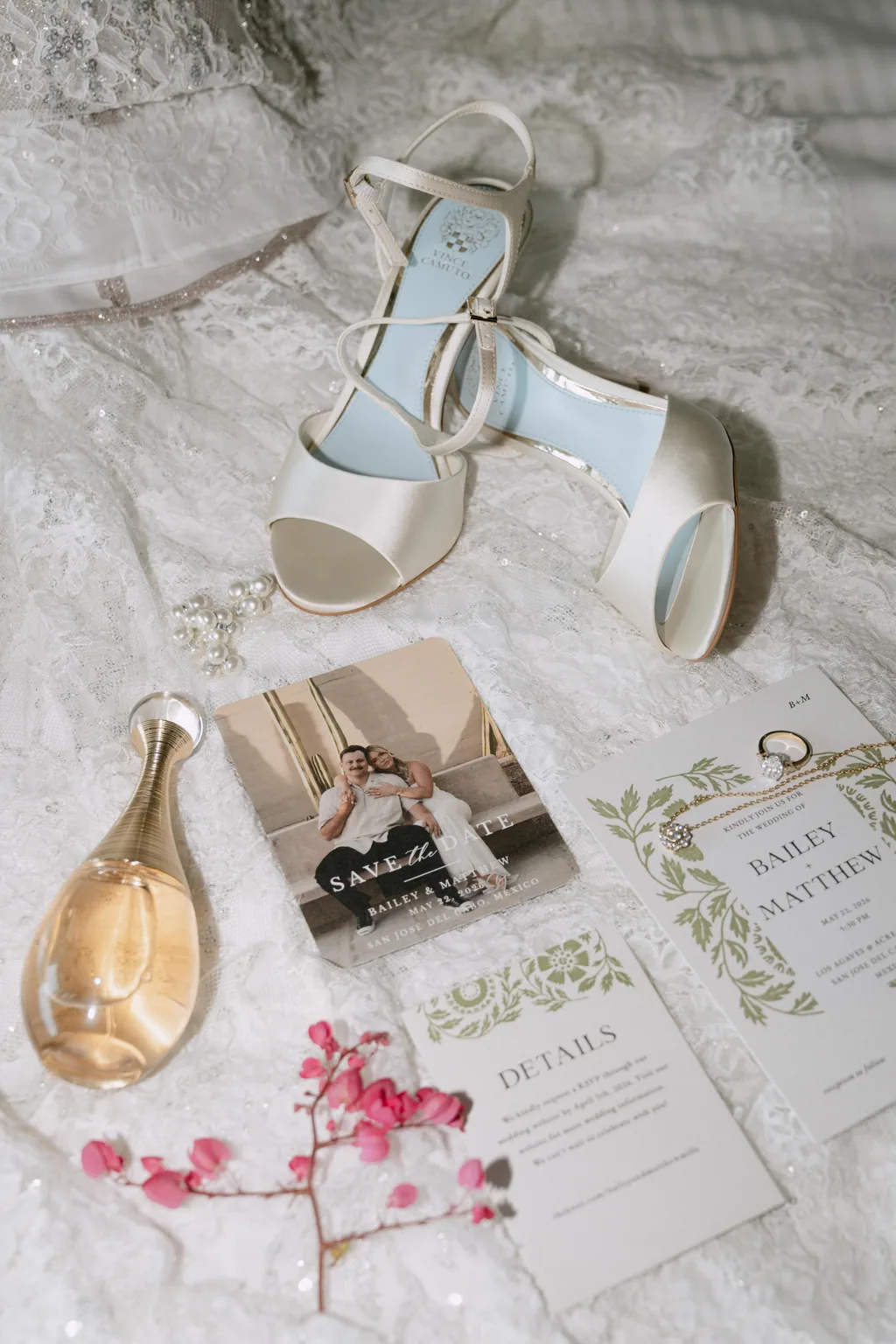 The bride's shoes, perfume and wedding invitation laid out together