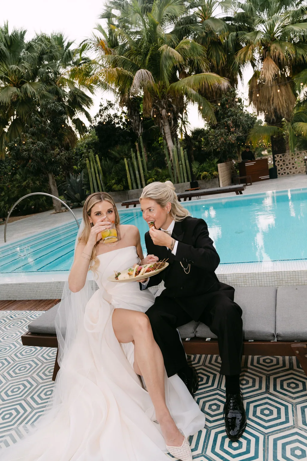 The two of them by the pool with a drink