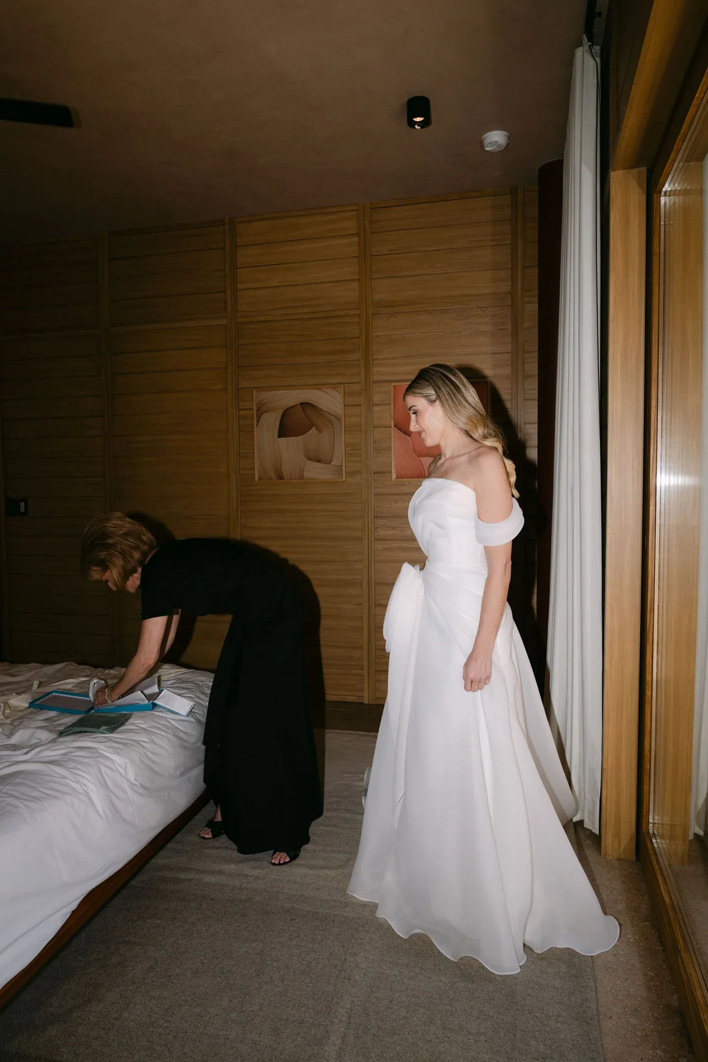 Getting ready in the room, the gown catching the window light