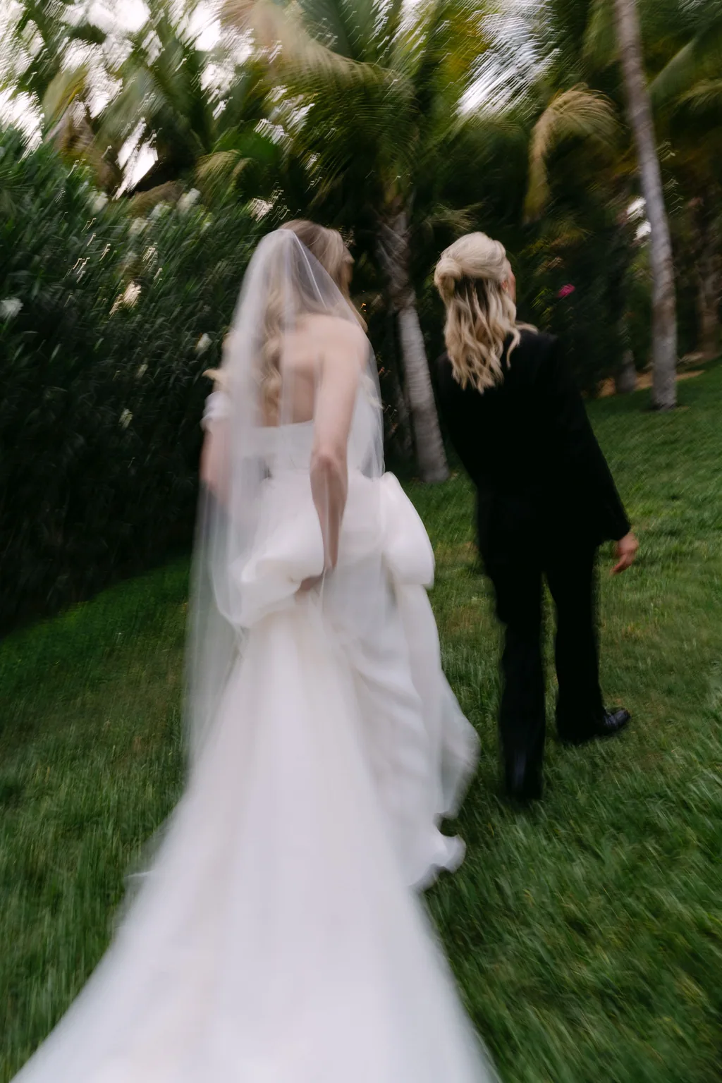 Her veil and her back, walking across the grass