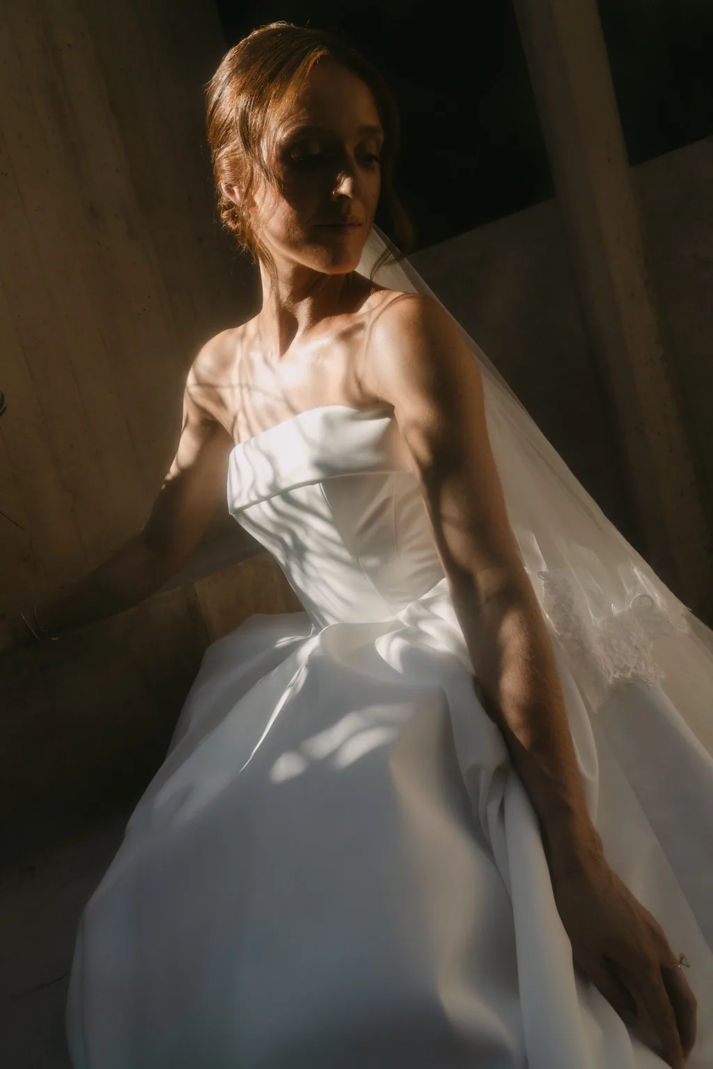 Lauren in a slash of afternoon light against the concrete at Acre