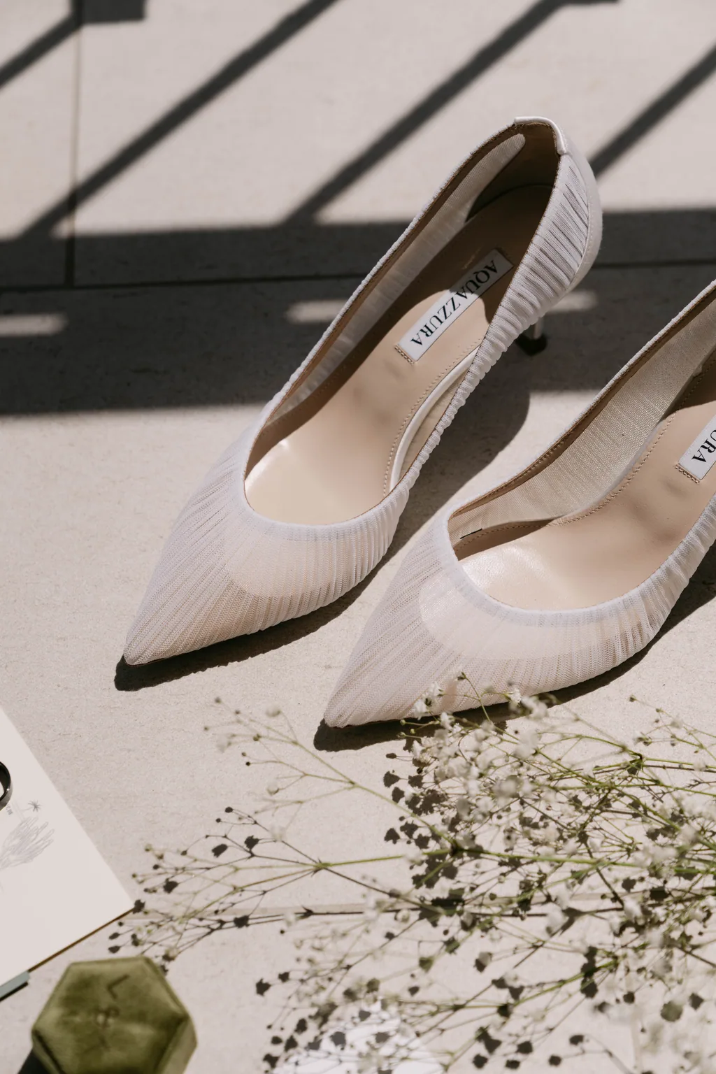 Her heels and baby's breath in a hard shaft of afternoon light