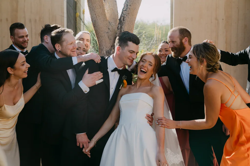 The whole wedding party crowding in around Lauren and Tevyn, laughing