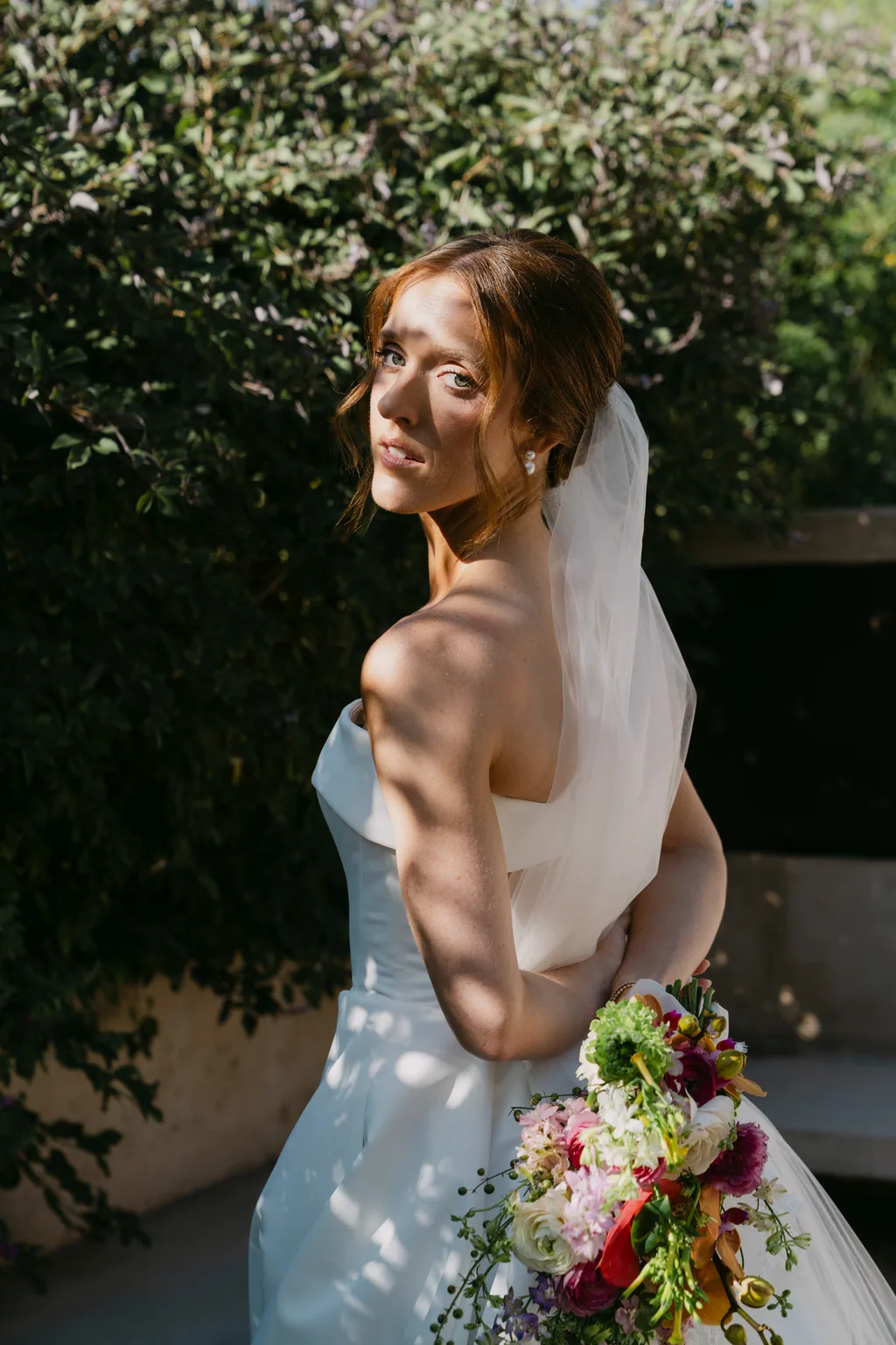 Lauren from behind, her veil down her back, holding her bouquet